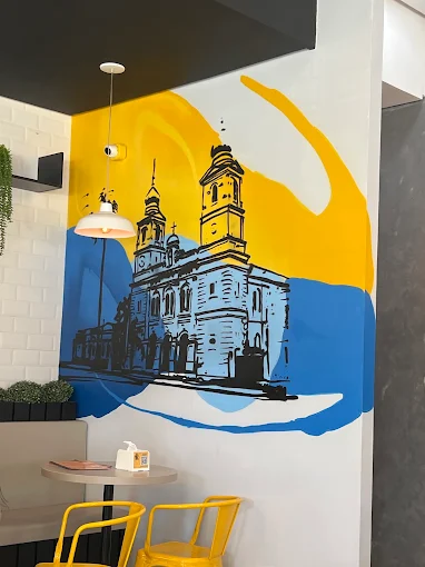Mural ilustrado e mesa no ambiente da Freguesia